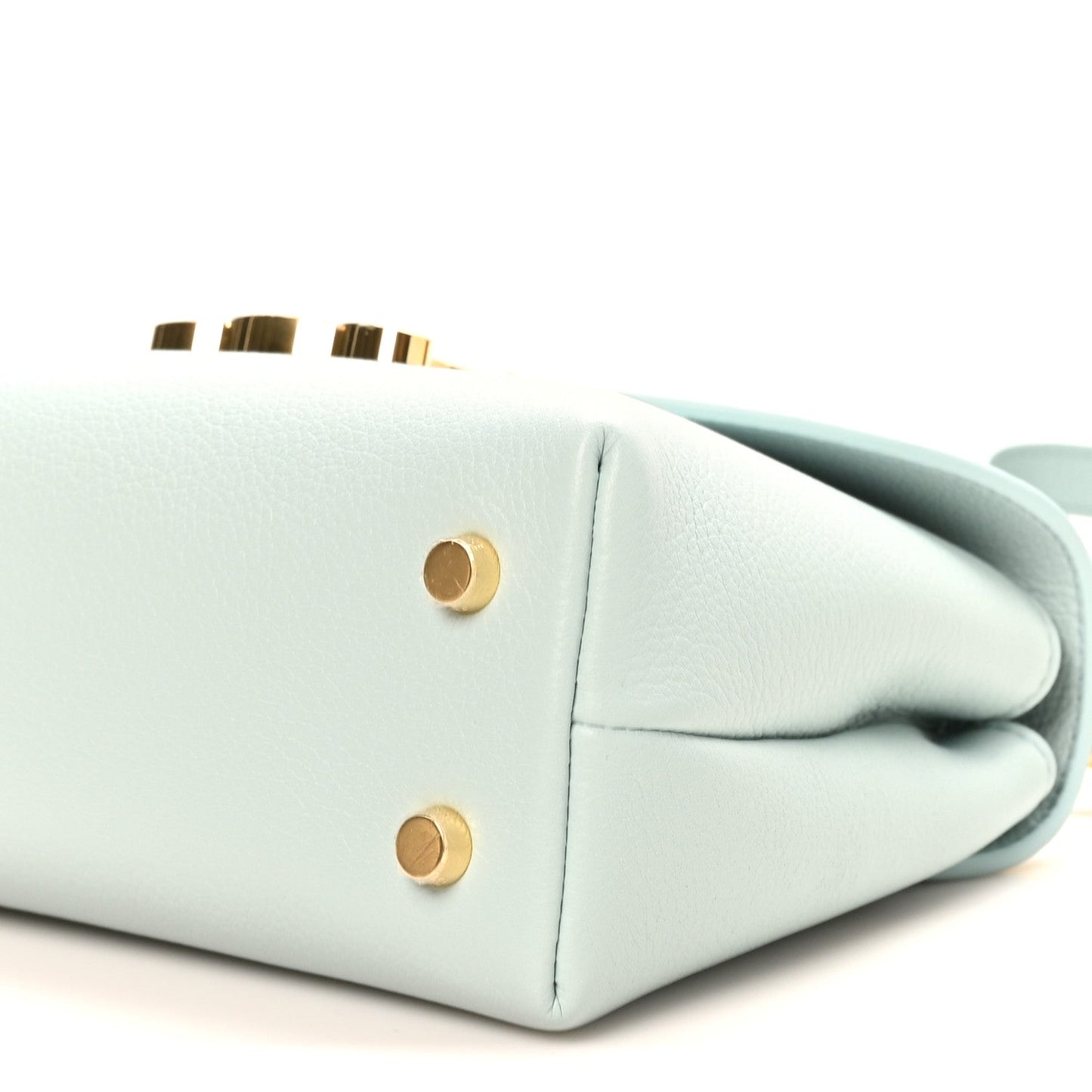 Light blue leather handbag corner with gold snap buttons and strap loop