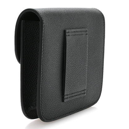 Hermes Constance slim wallet in black with embossed texture and front flap, side view