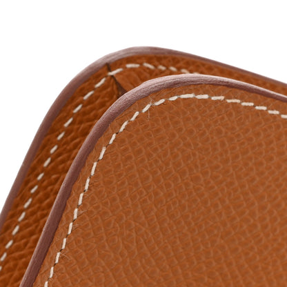 Brown Epsom leather wallet corner with white saddle stitching and curved top edge.