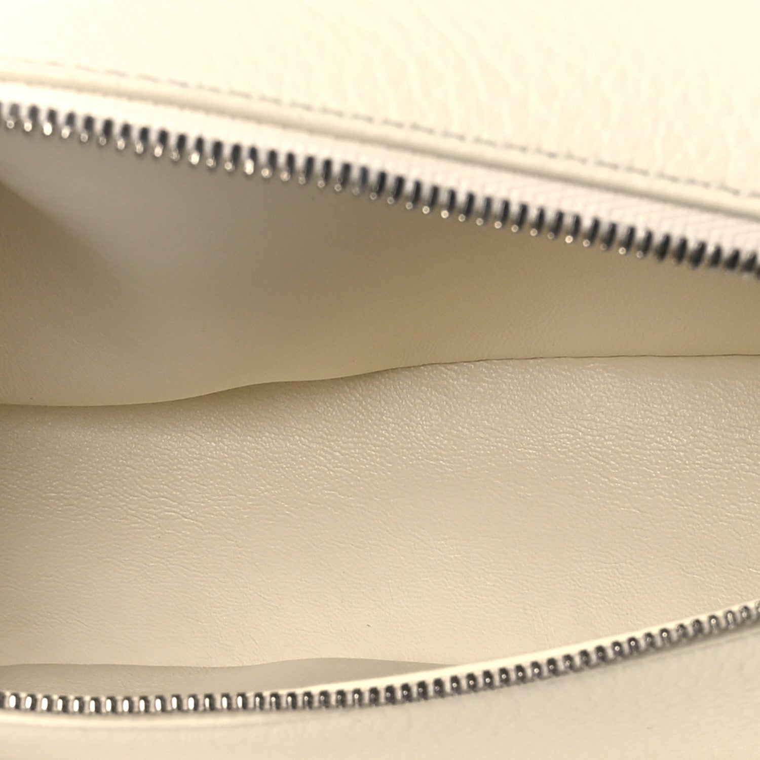 Pouch interior view showing zipper track, smooth lining, and grained leather edge