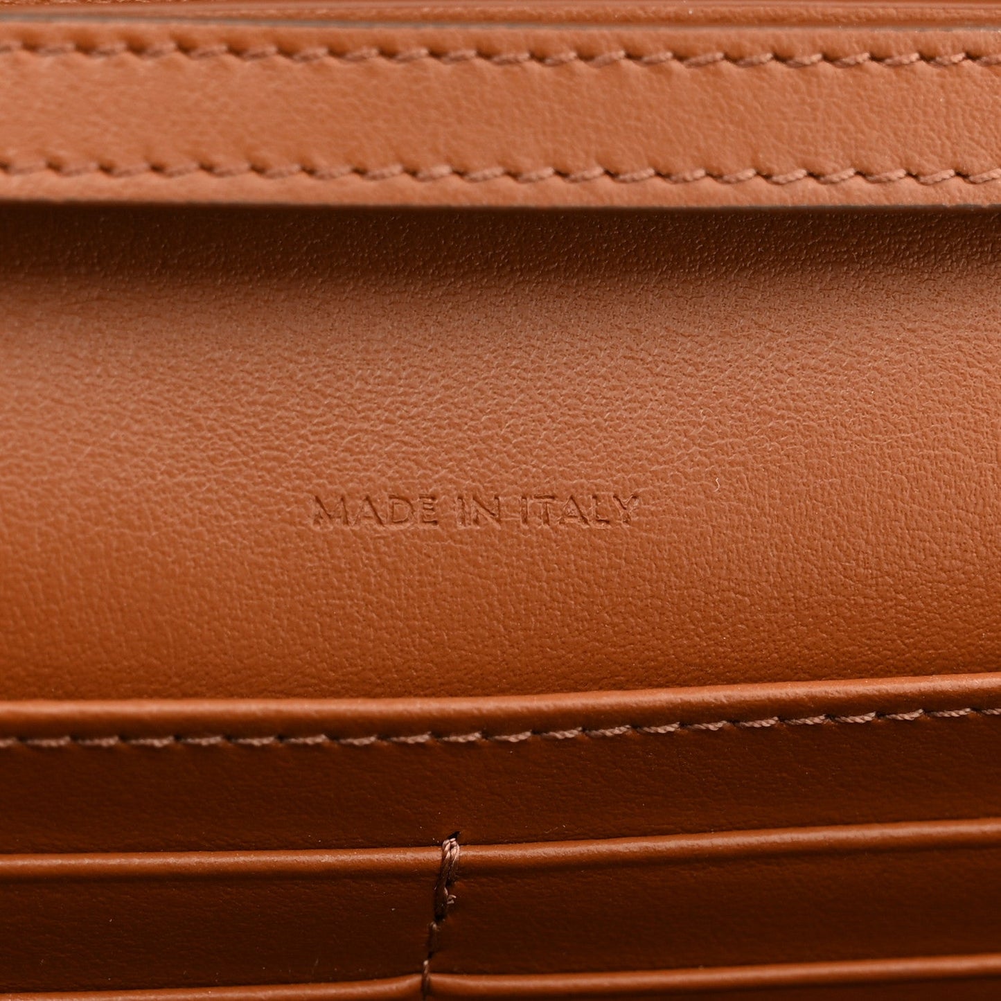 Tan leather interior with "MADE IN ITALY" embossed text and stitching