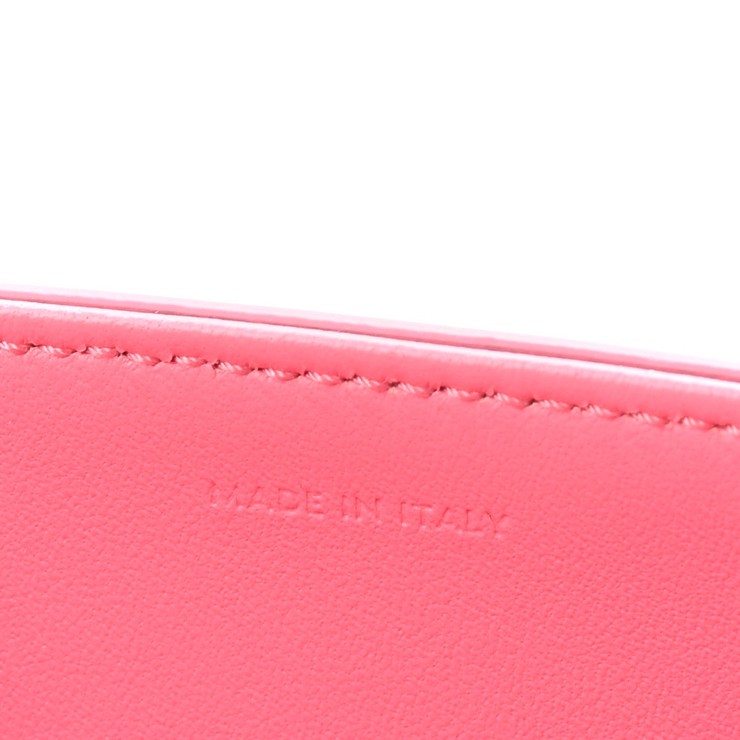 Flamingo pink leather with fine edge stitching along the top rim