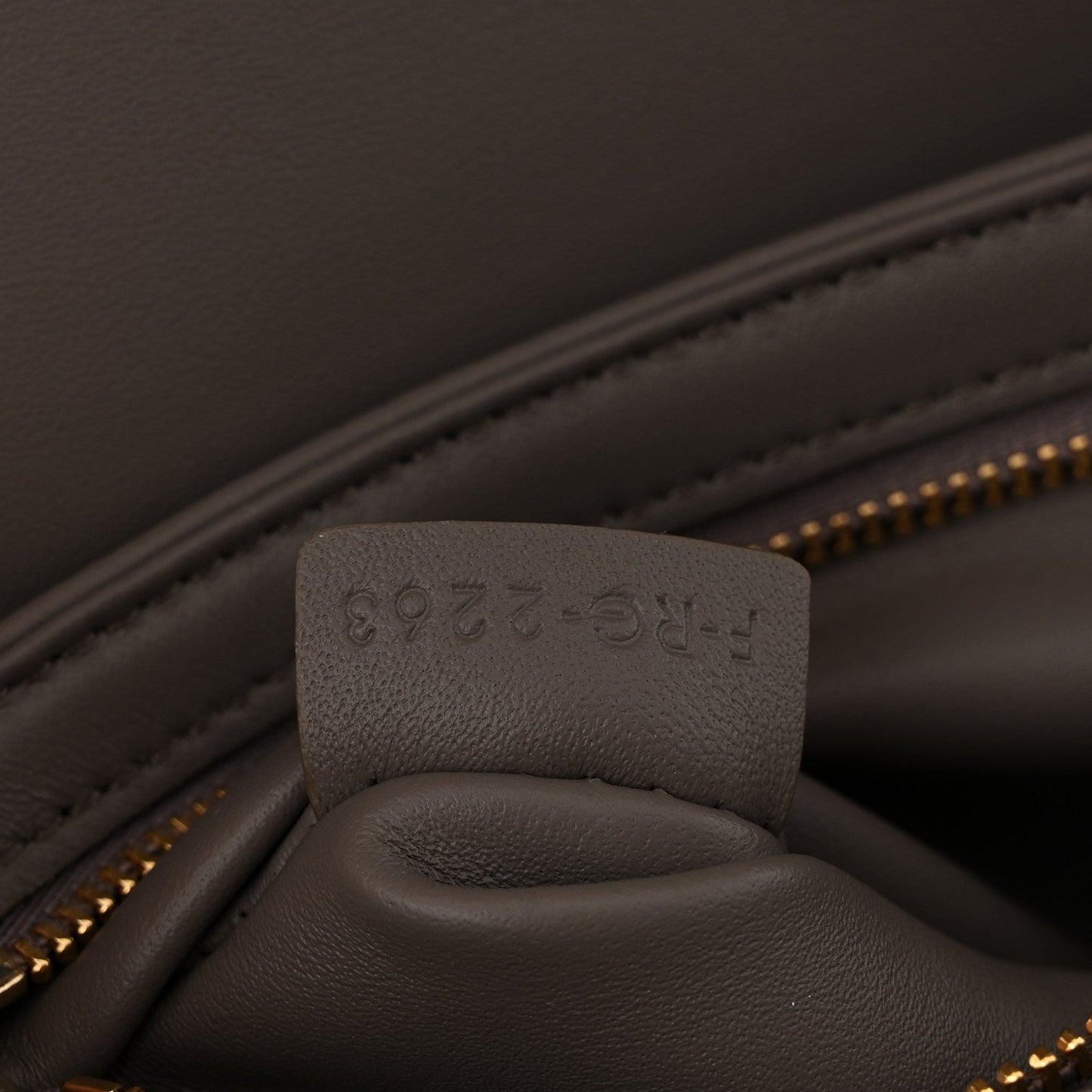 Close-up of interior pocket and stamped leather tab inside Celine bag