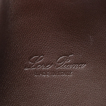 Loro Piana logo embossed on dark brown lizard leather pouch surface