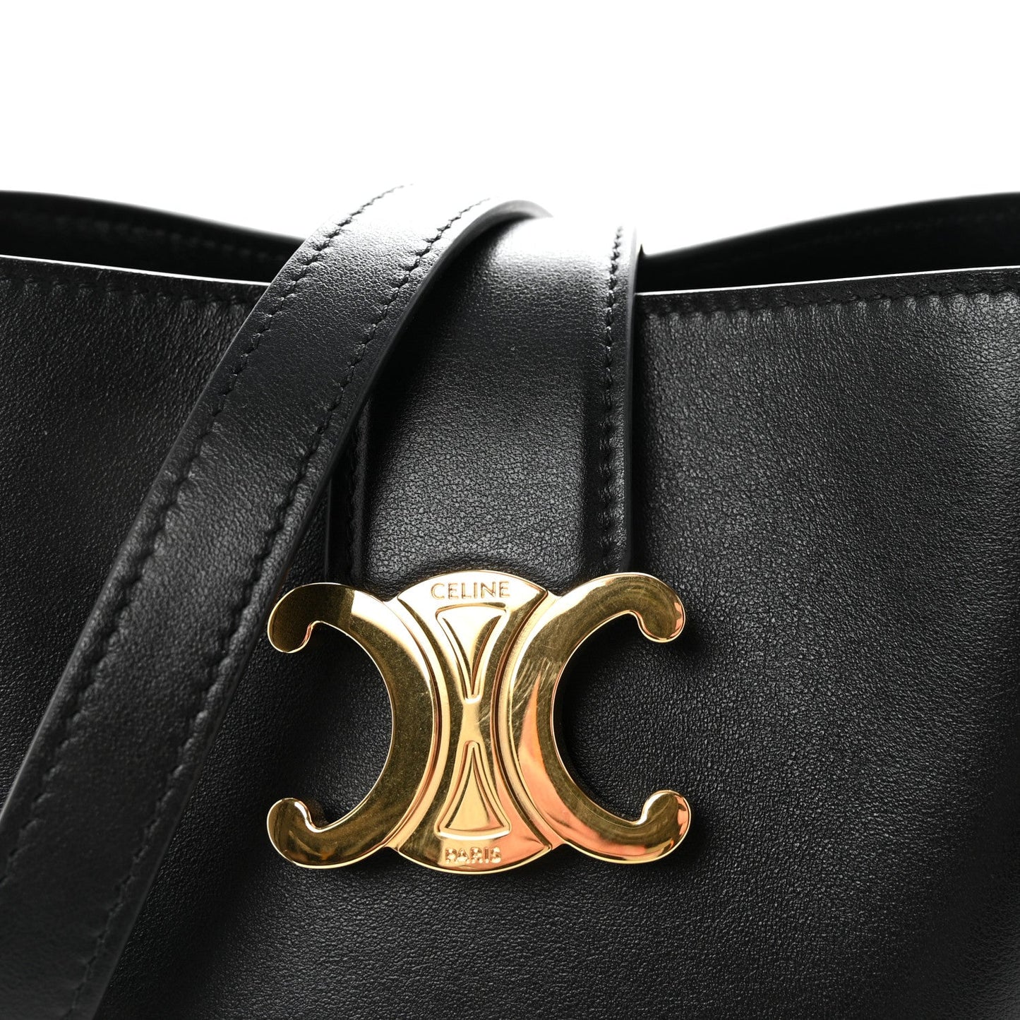 Close-up of gold Triomphe logo on black Celine leather with side handles