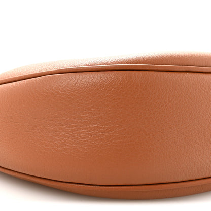 Tan leather hobo bag front panel close-up with smooth grain and curved seam