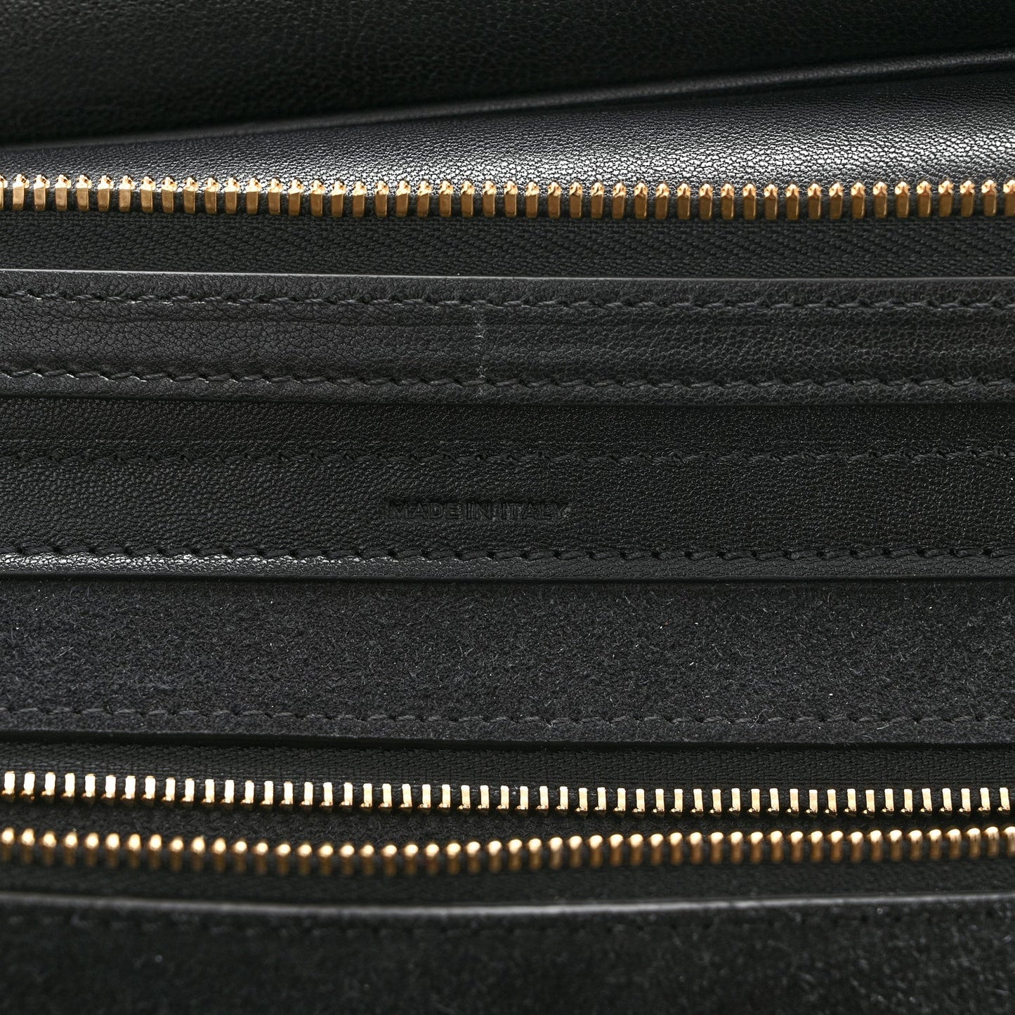 Celine black leather close-up with gold zipper track and stitched panels
