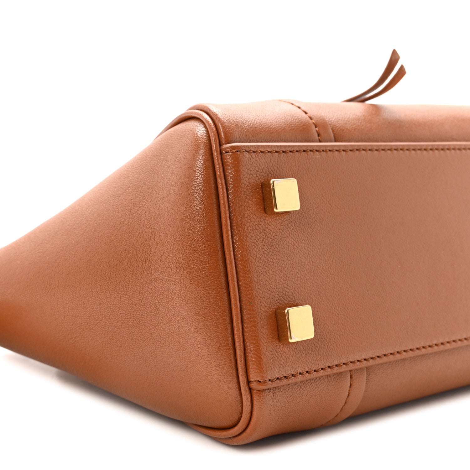 Tan leather tote front corner with gold-tone stud hardware and seam stitching