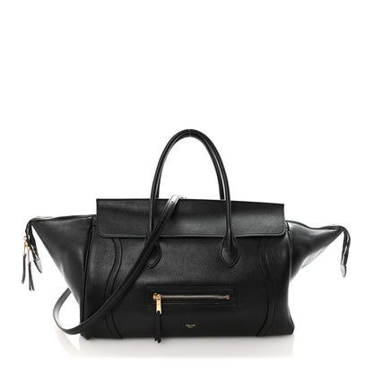Black leather luggage bag with top handles and front zip pocket.