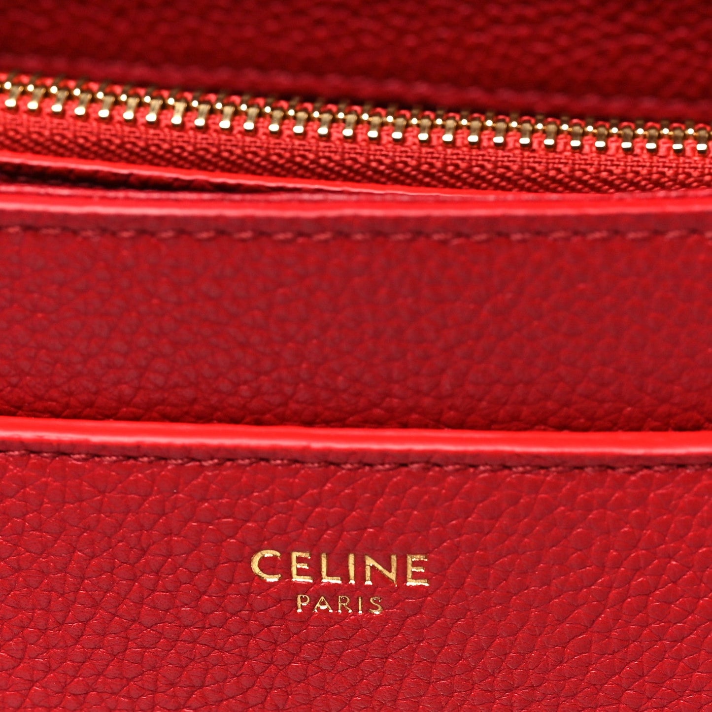 Celine red leather interior label with gold 'CELINE PARIS' embossing.