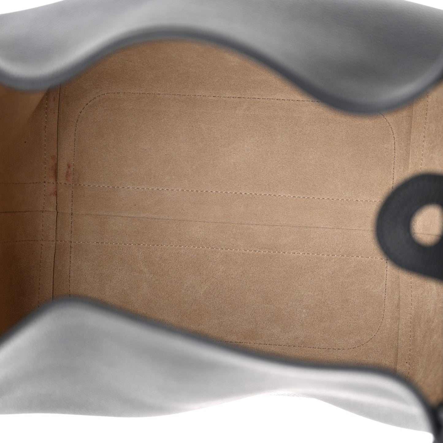 Tan leather interior lining with stitched seams and curved upper edge