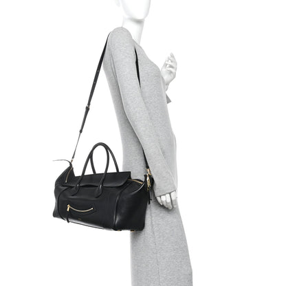 Celine black leather tote with shoulder strap, worn by a model