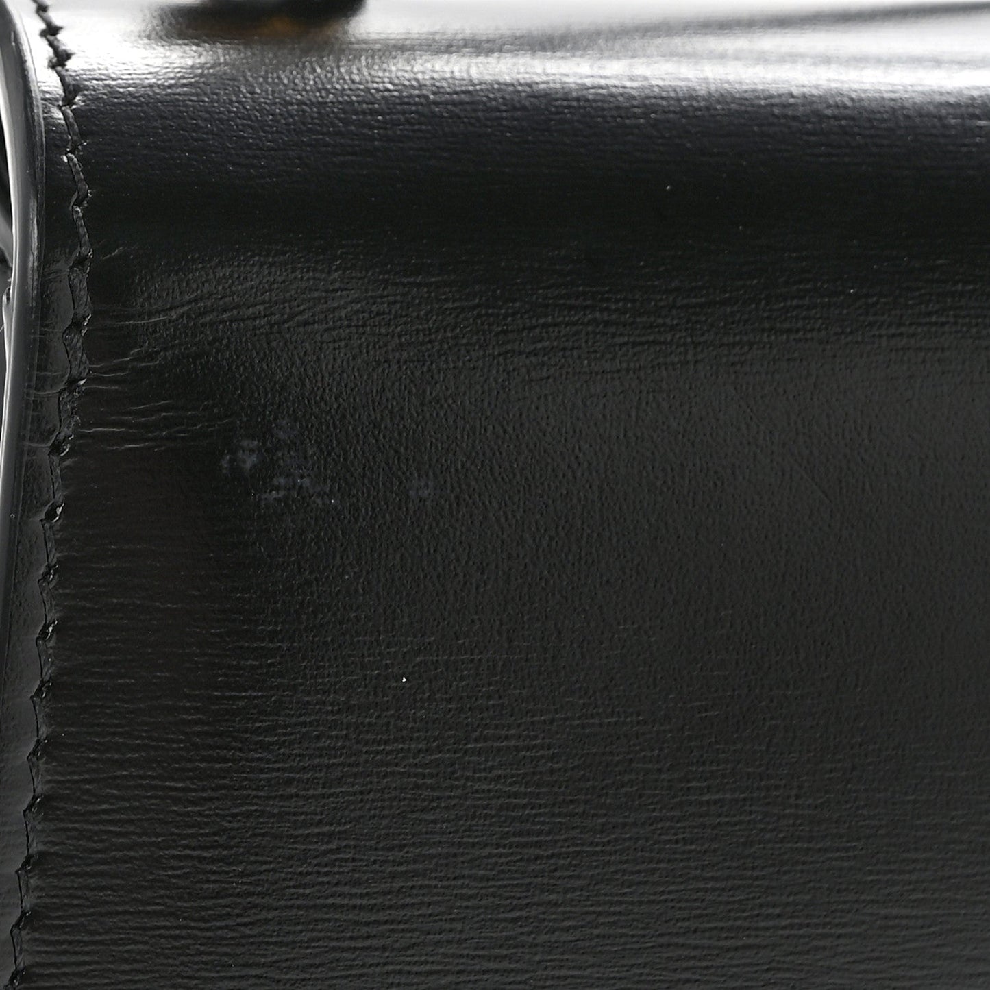 Black shiny calfskin with visible stitching and smooth edge close-up