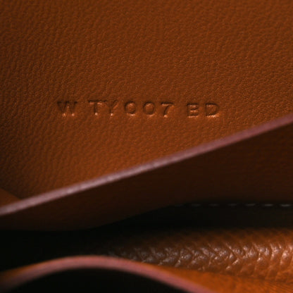 Constance slim wallet embossed serial marking on tan leather surface
