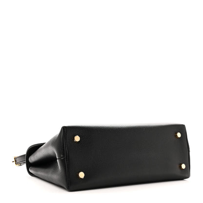 Black leather handbag bottom corner with gold studs and attached strap loop
