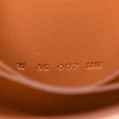 Brown leather wallet close-up with embossed dot pattern and smooth edge finish.