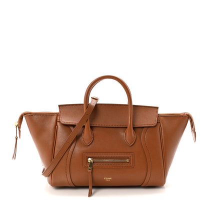 Tan leather tote with top handles, front zipper pocket, and adjustable crossbody strap