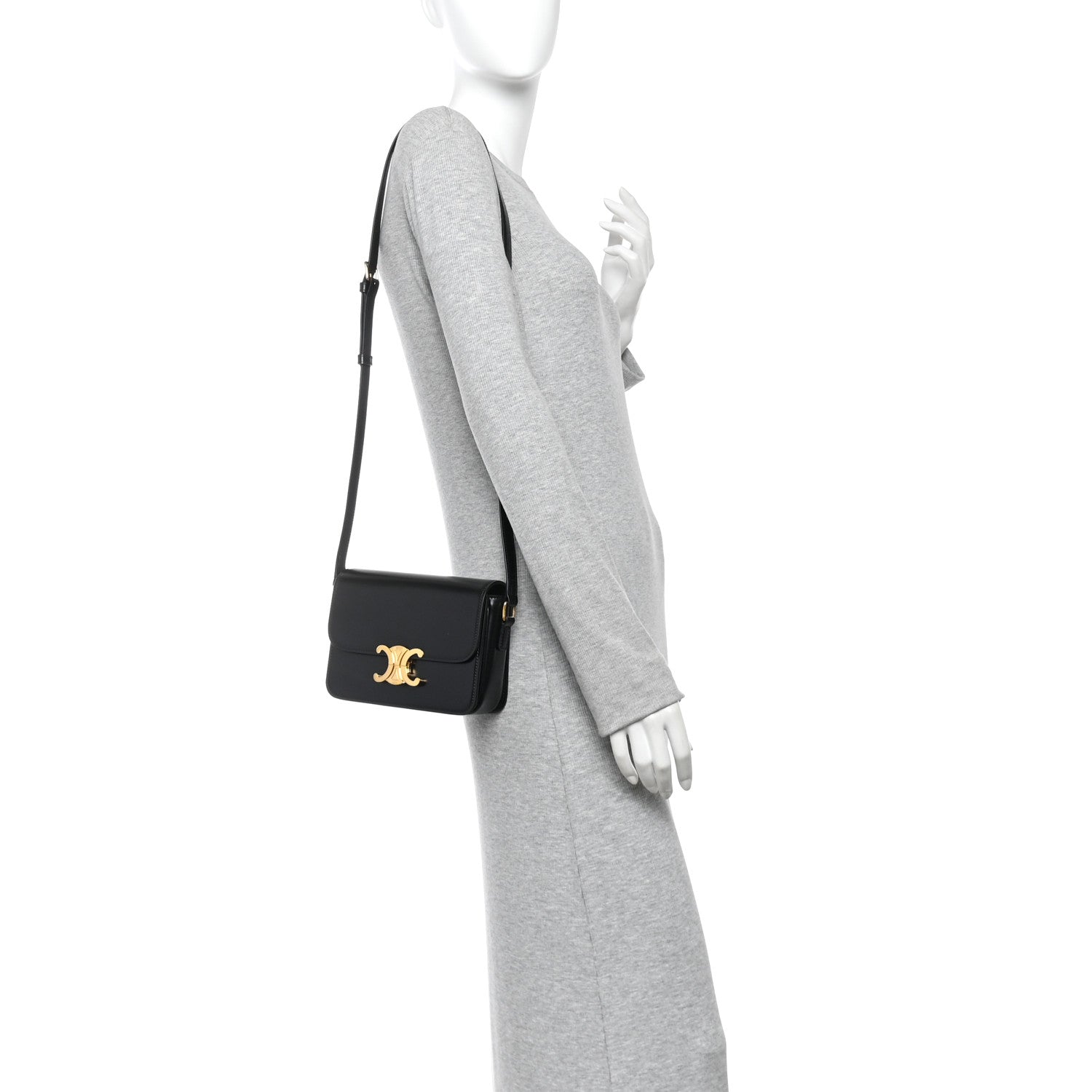Black mini shoulder bag on model with gold logo, worn crossbody with slim strap.