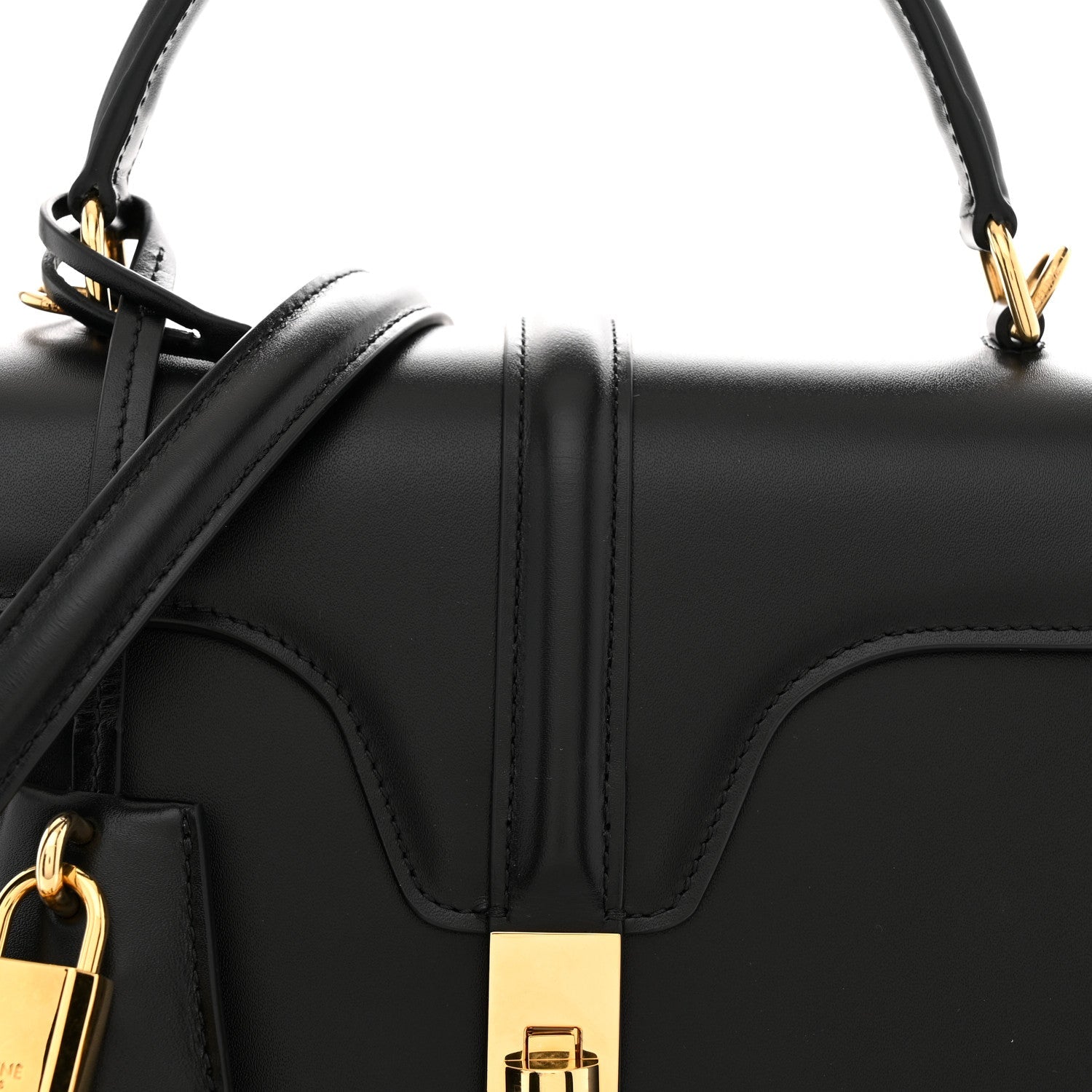Black satin calfskin bag front with top handle, gold hardware, and front strap details