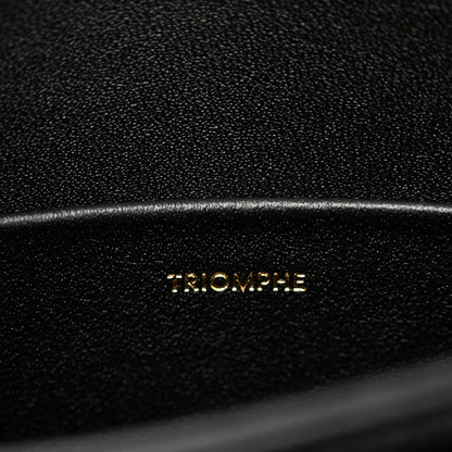 Black leather bag surface with 'TRIOMPHE' embossed lettering and fine grain texture.