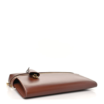 Loro Piana smooth calfskin clutch in burnt tan with rounded clasp and gold zipper