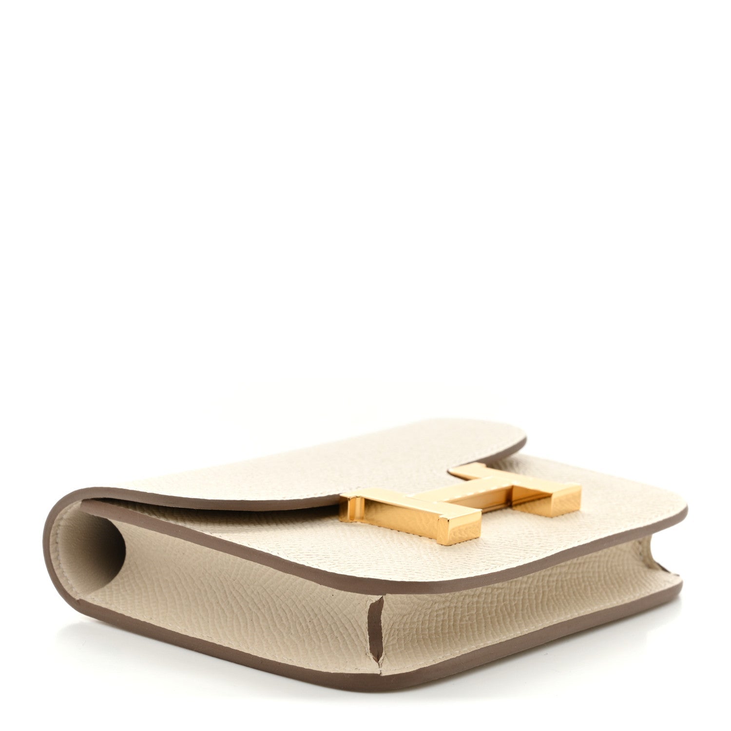 Slim wallet with gold H clasp, angled view on light cream textured leather