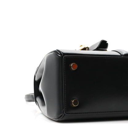 Celine mini bag side detail in black leather with gold snaps and small round emblem