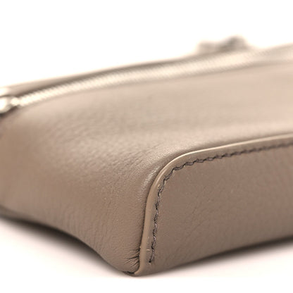 Corner detail of a mini grained leather pouch with visible edge stitching