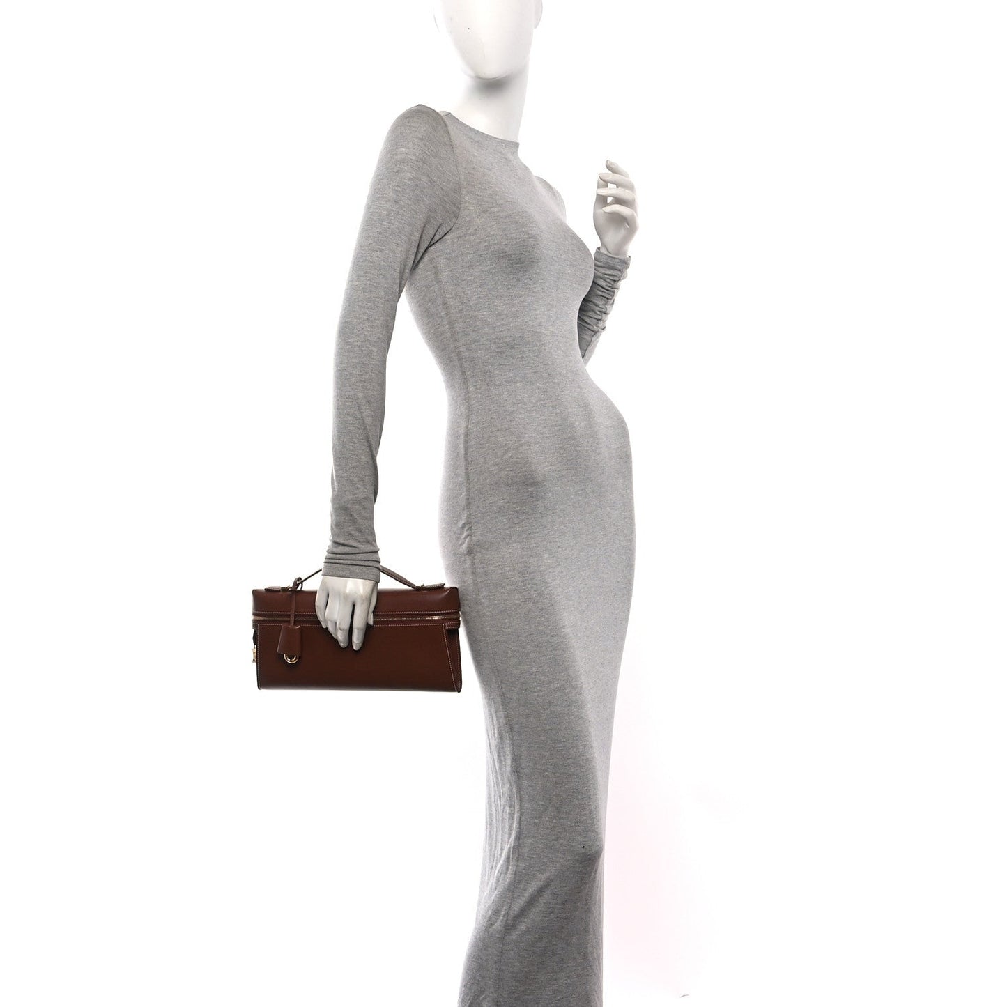 Loro Piana smooth calfskin clutch in burnt tan, held by model at side