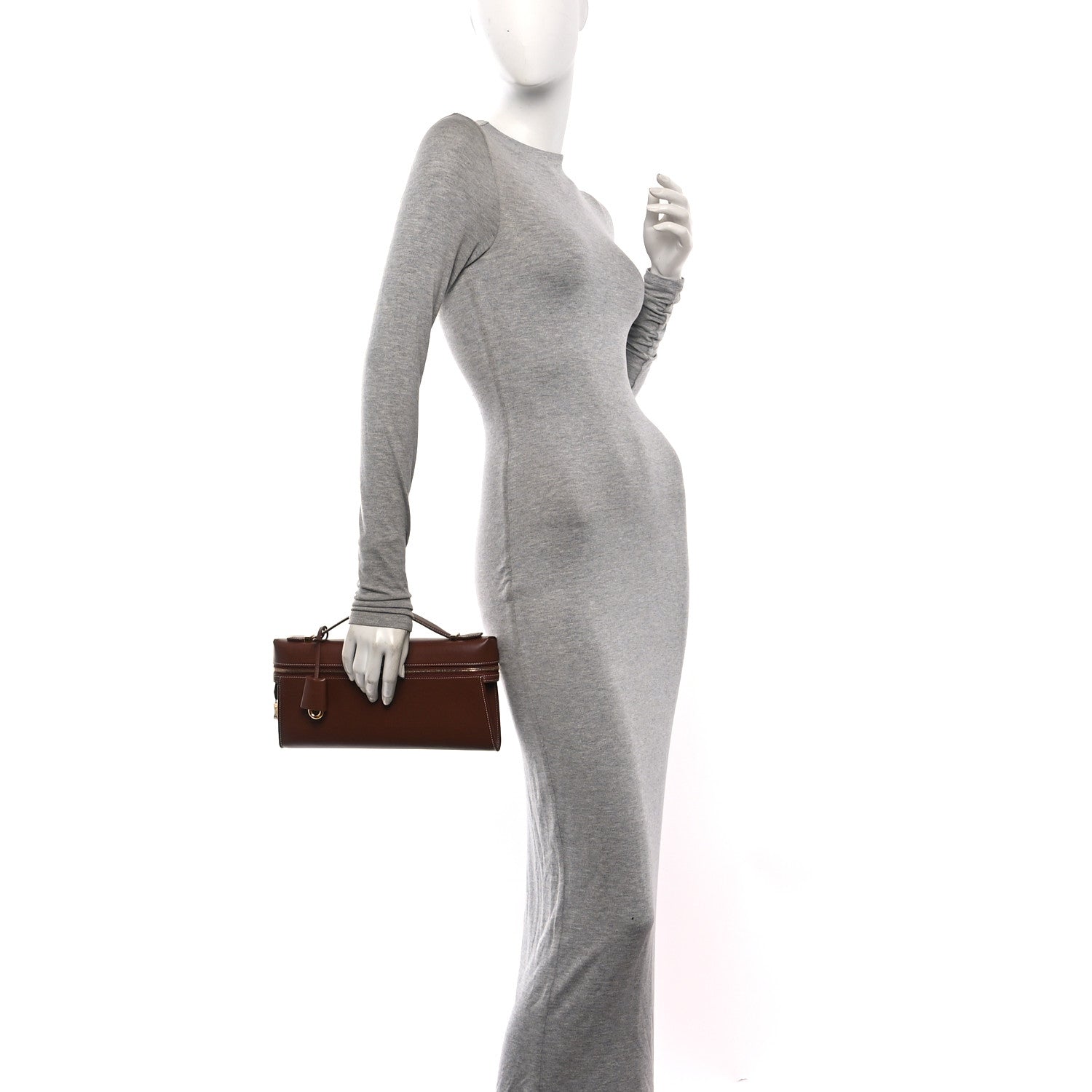 Loro Piana smooth calfskin clutch in burnt tan, held by model at side