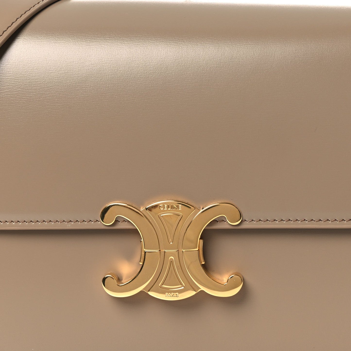 Gold Triomphe clasp emblem on shiny beige leather flap