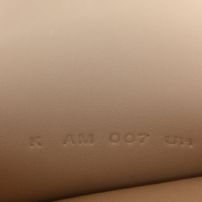 Stamped code on light cream leather, faint marks visible