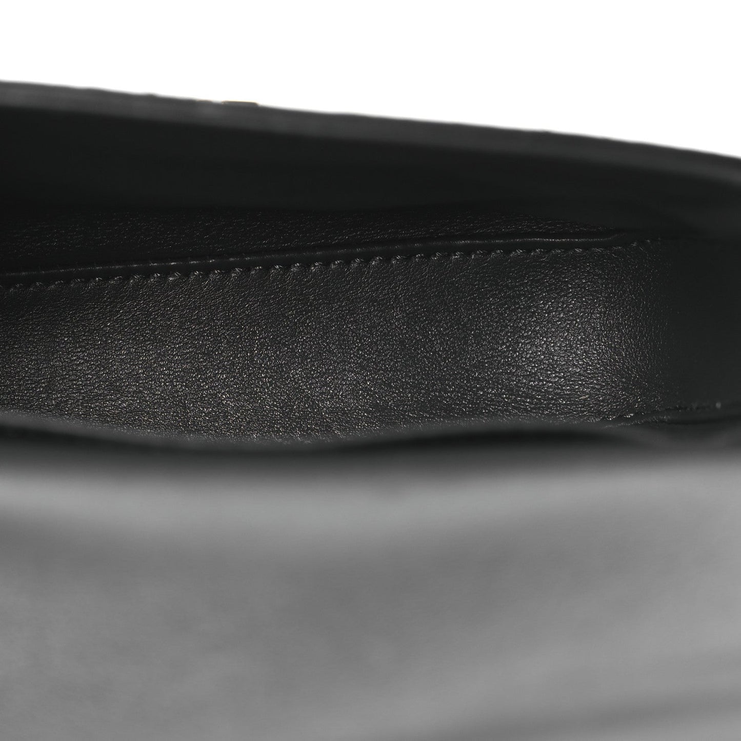 Close-up of black leather strap edge on grey snakeskin shoulder bag