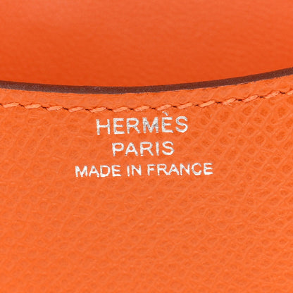 Hermes Paris Made in France stamp on orange leather slim wallet.