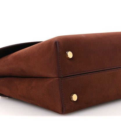 Chestnut brown leather bag corner with gold snap hardware and seam stitching.