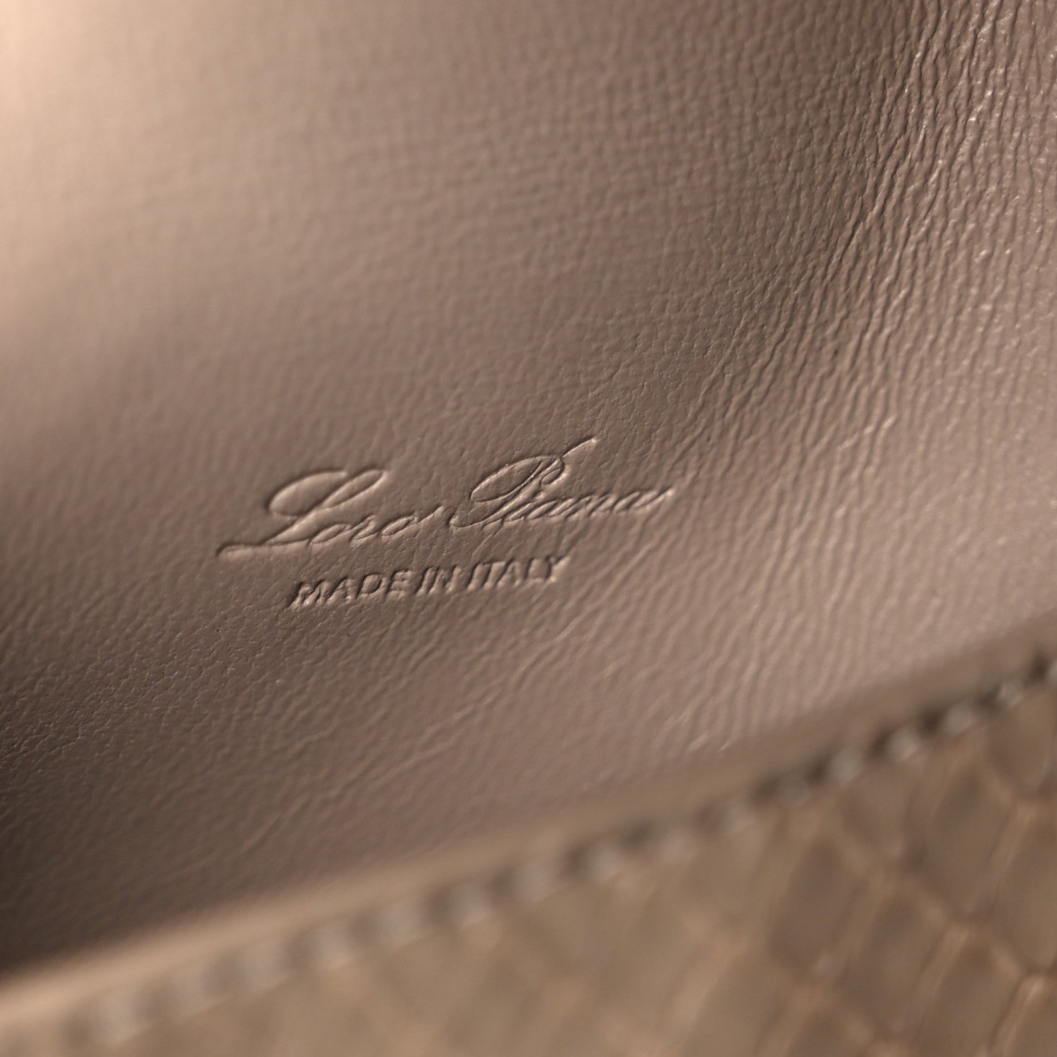 Matte snakeskin handbag close-up of embossed Loro Piana logo on front panel