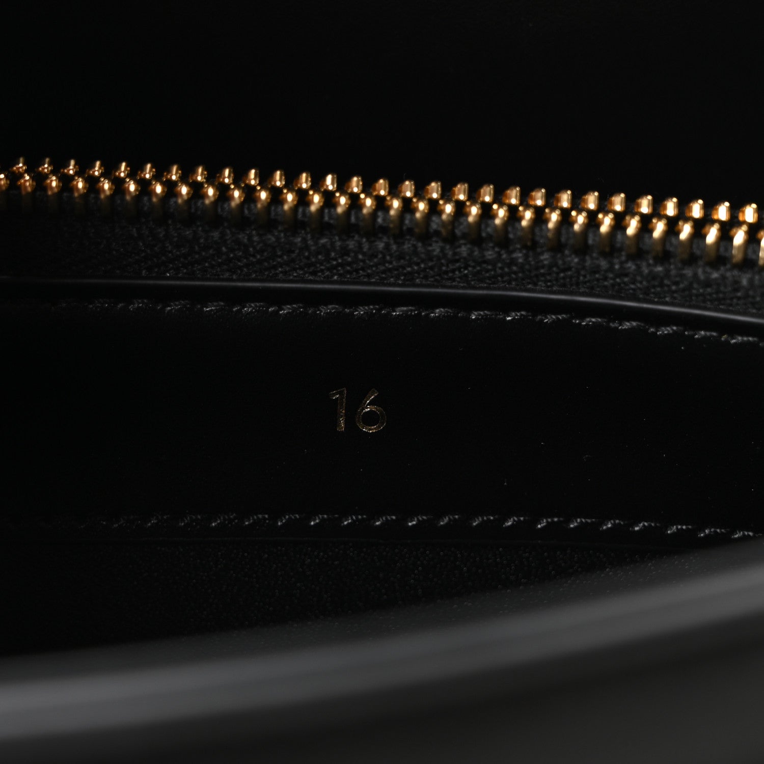 Celine mini bag close-up of beaded zipper and “16” stamp on black leather