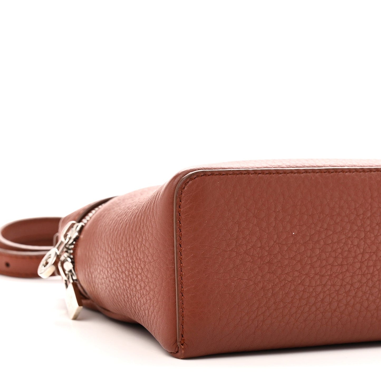 End view of grained calfskin pouch with top zip and attached leather strap