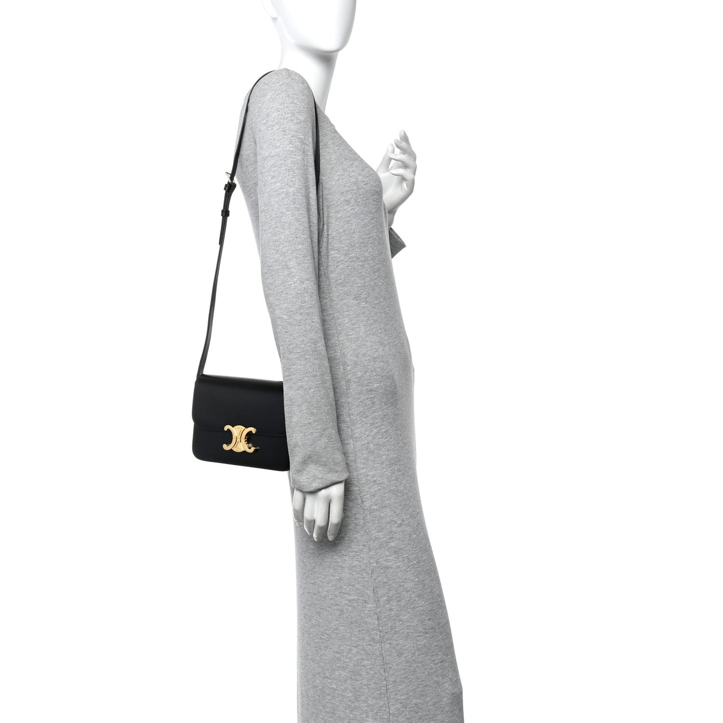 Small black leather crossbody bag on model with gold logo hardware and flap closure.