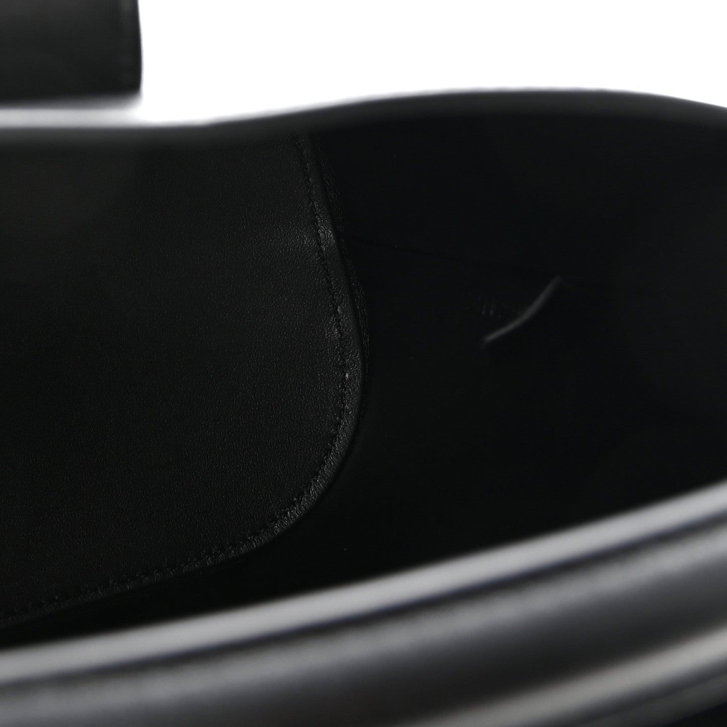 Close-up of smooth black leather bag panel with neat stitching seam