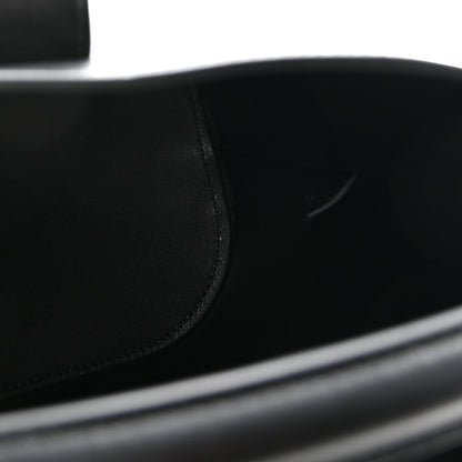 Close-up of smooth black leather bag panel with neat stitching seam
