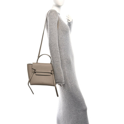 Celine light taupe micro belt bag on a model, side view with crossbody strap