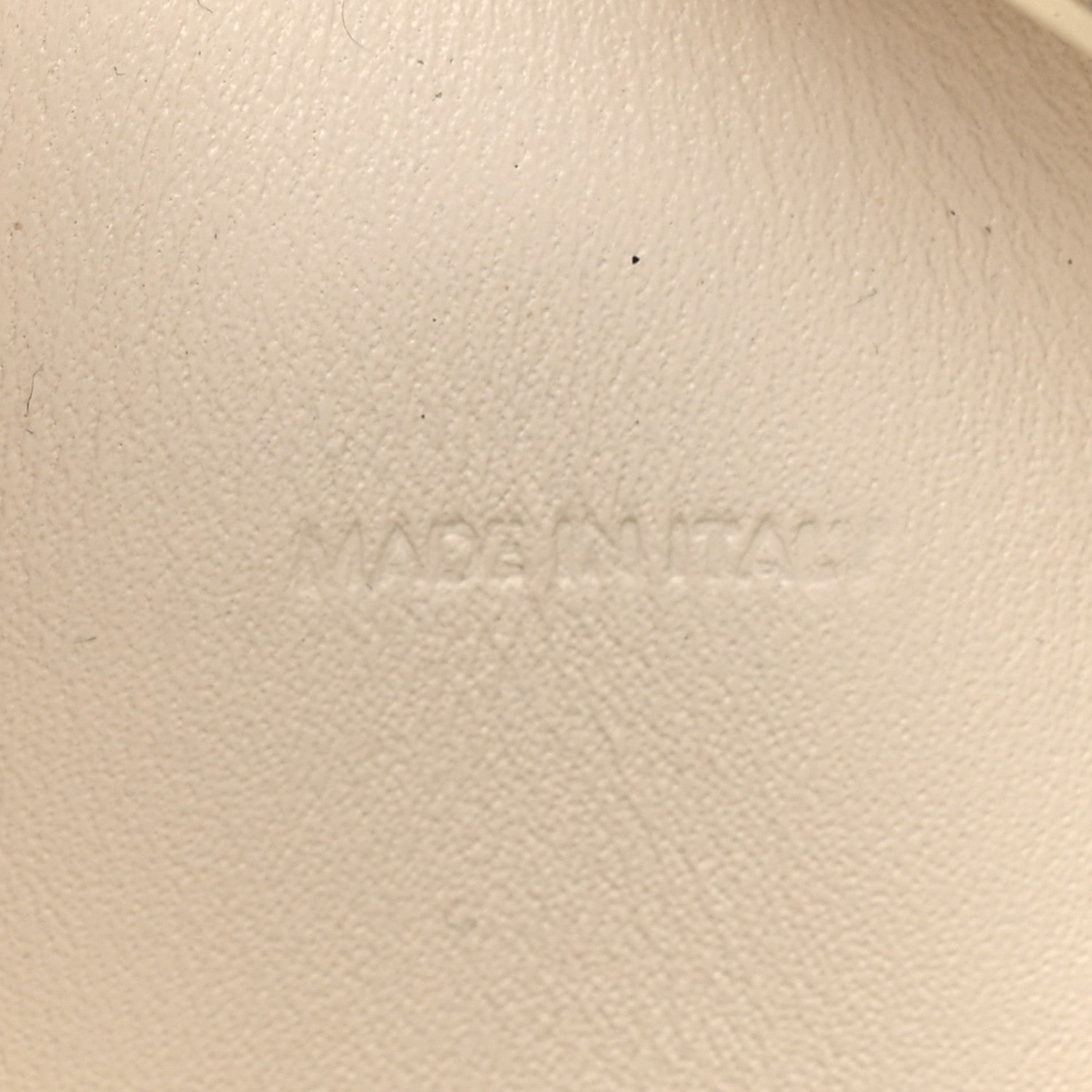 Light rice cream leather surface with faint embossed branding