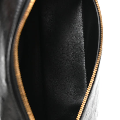 Close-up of black interior lining and gold-tone zipper at pouch opening