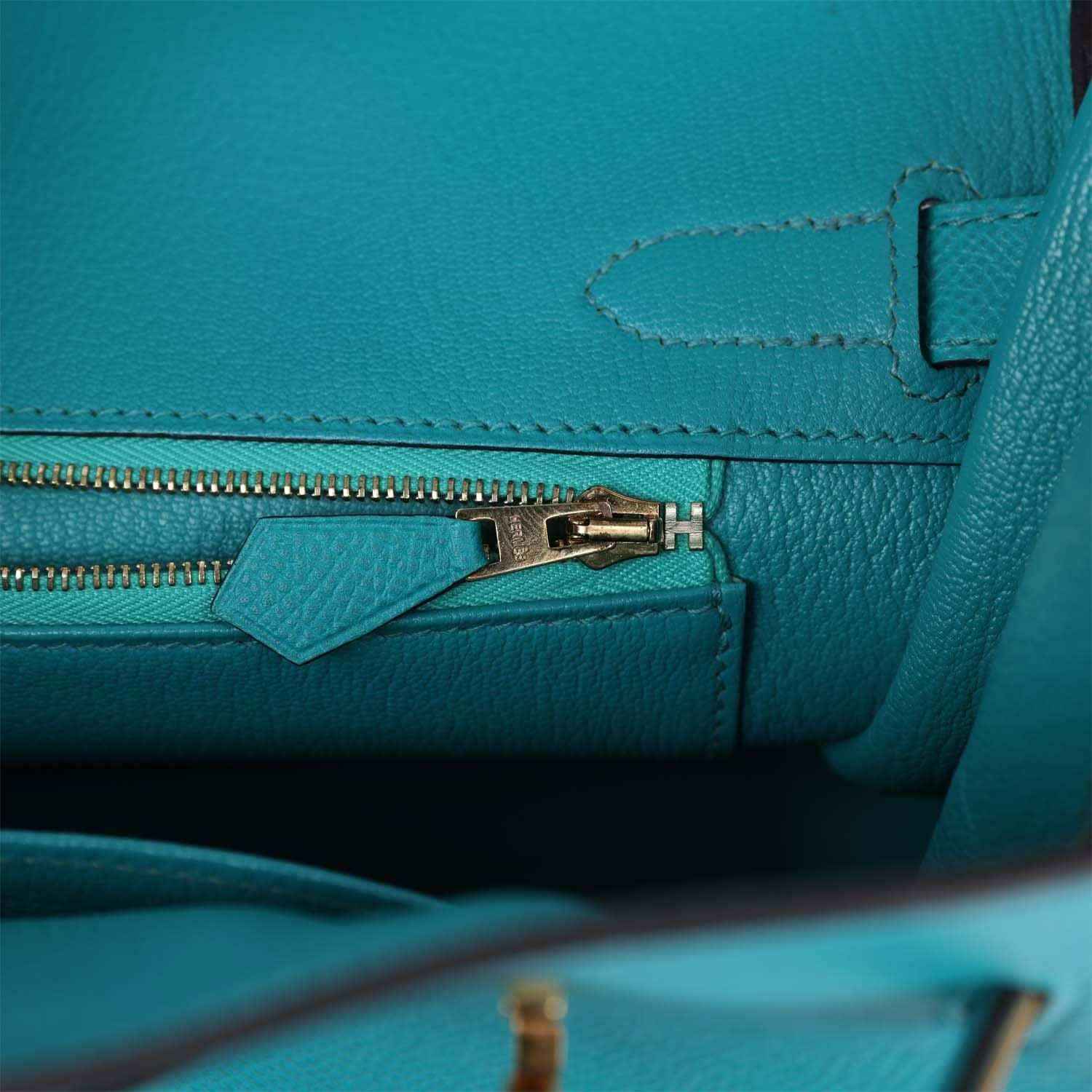 Elegant turquoise leather handbag interior with gold zipper and refined stitching
