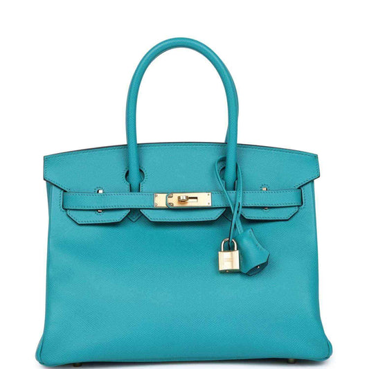 Elegant turquoise leather handbag with gold hardware and a timeless, sophisticated design.