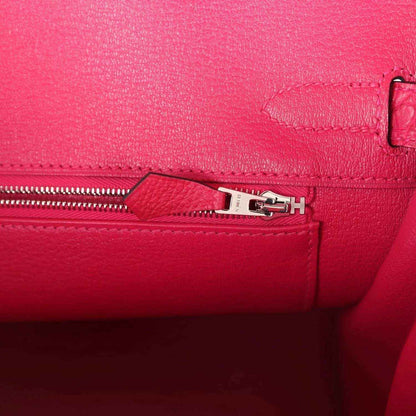 Elegant pink leather handbag interior with silver zipper, showcasing timeless sophistication