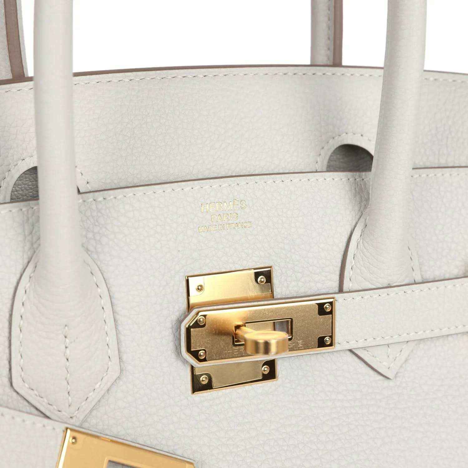 Elegant white leather handbag with gold hardware and textured finish, sophisticated and timeless.