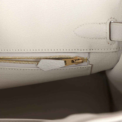 Elegant white leather handbag interior with gold zipper, sophisticated and timeless.