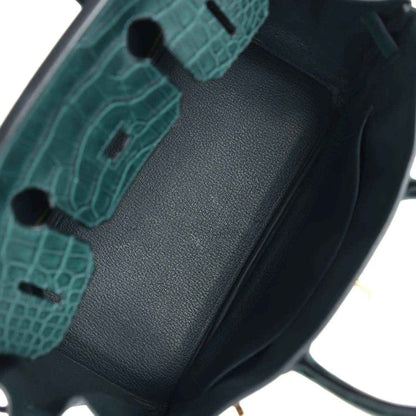 Elegant dark green leather handbag interior with refined, timeless crocodile-texture detail
